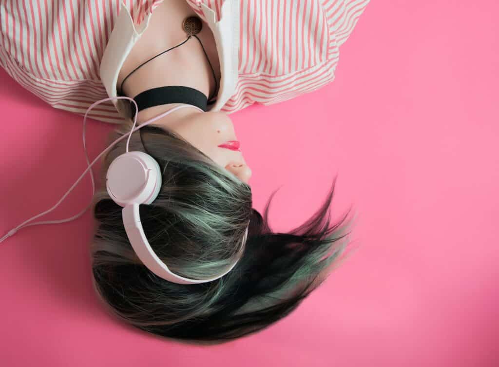 Person lying down with headphones on, representing the need to avoid branded podcast mistakes to keep listeners engaged.