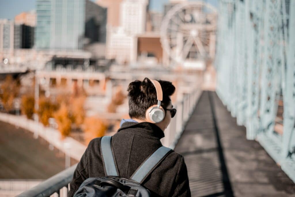 guy listening while walking on a bridge about audience growth rate benchmark