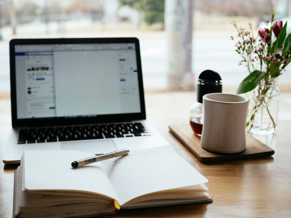 a desk with a cup of tea and a book about how to produce a podcast