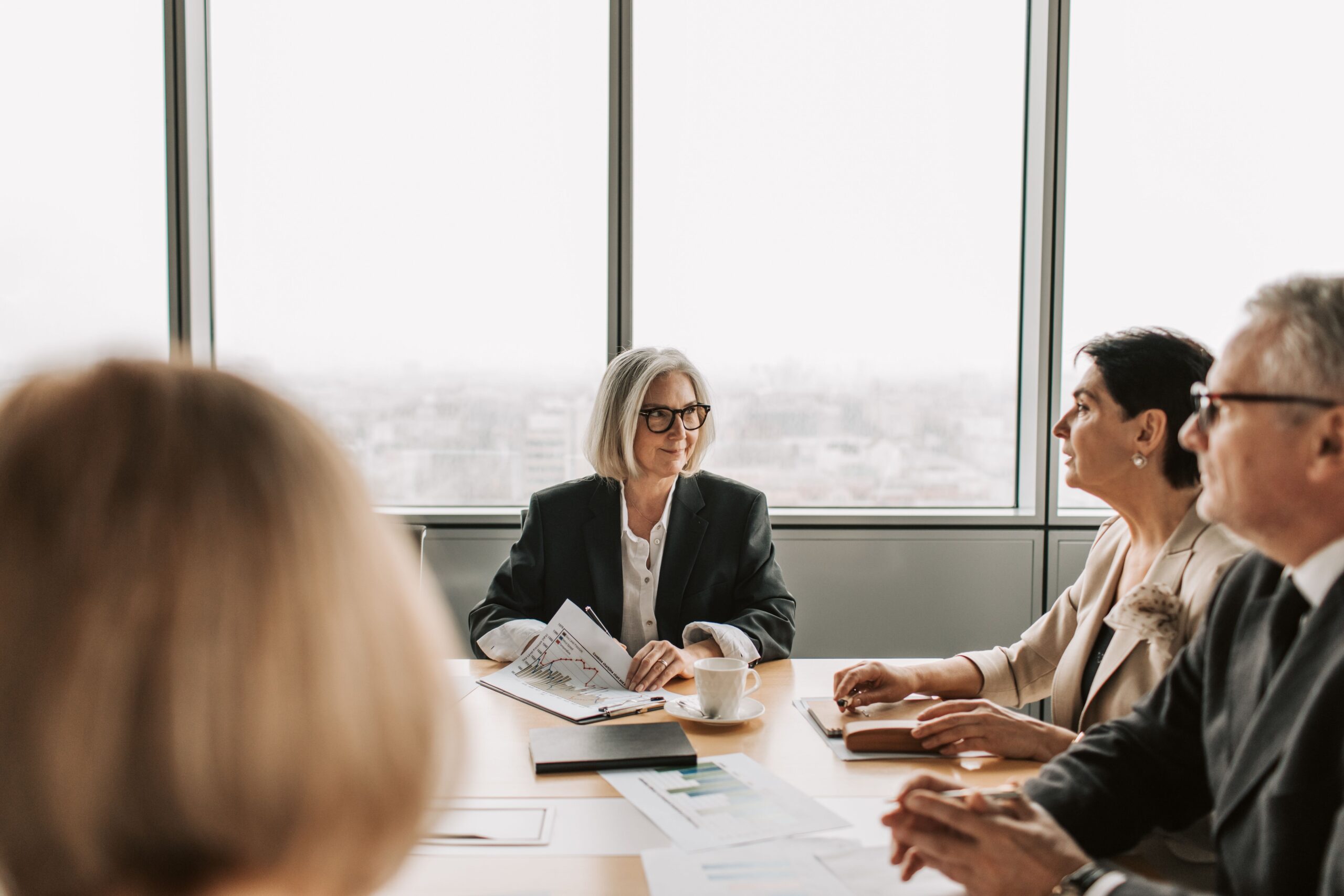 Senior executives in a leadership meeting discussing strategy around a boardroom table